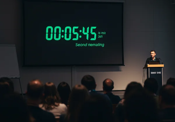 A large digital countdown timer on a screen during a presentation
